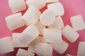 Marshmallows on a pink background close up and copy space. Marshmallow pattern top view on pink background.