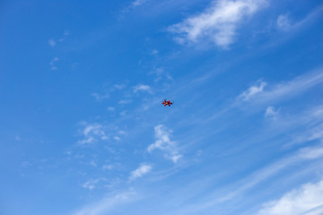 Obraz na płótnie Canvas very small toy drone for kids against blue sky, in to the air