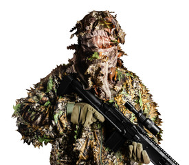 Isolated soldier in camouflaged masking forest leafs suit with rifle.