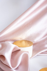 beige podium - top hat with gold top on pink satin background with folds. Luxurious showcase for advertising and product promotion..