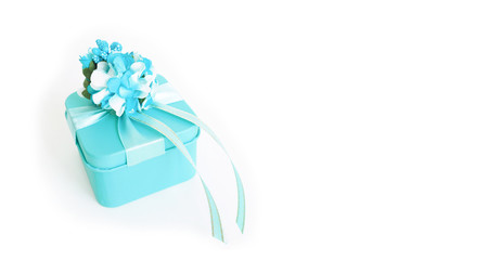 banner: a blue gift box with a flower and ribbons on a white background. copy space..