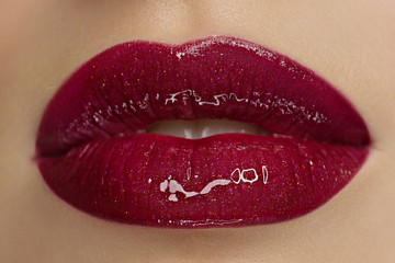 close up the beauty of female lips with red lipstick. kiss on camera. Clean skin and makeup. beautiful girl and lip gloss