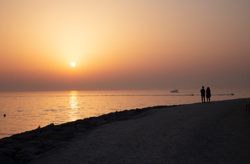 Fototapeta na wymiar Bubai - The silhouette of pair on the coast at the sunset light,.