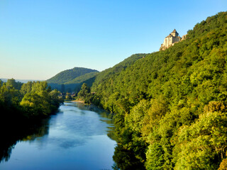Fototapeta na wymiar River Dordogne at sunrise with Chateau Castelnaud in the background, perched on a limestone cliff