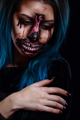 Portrait of bloody horrible scary zombie woman in a halloween festive makeup