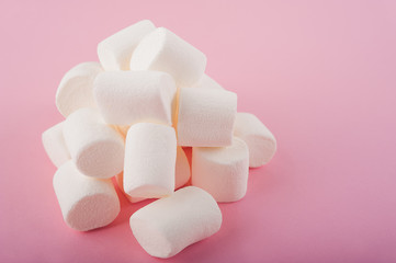 Marshmallows on a pink background close up and copy space. Marshmallow pattern top view on pink background.
