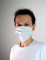 Woman wearing a face mask isolated on white background. Illustrative editorial photo for the Covid-19 pandemic.