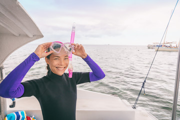 Snorkel watersport Asian woman tourist putting on mask for snorkeling activity in Miami, Florida,...