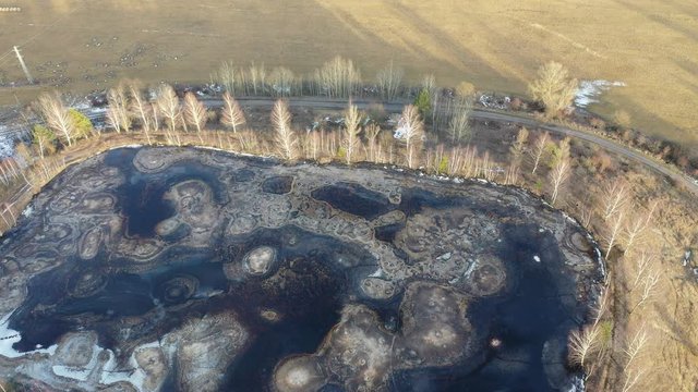 Descending flight to half frozen gudron toxic waste pit