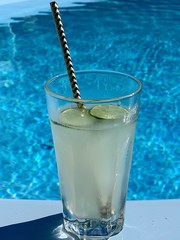 glass of cocktail with lemon on the pool