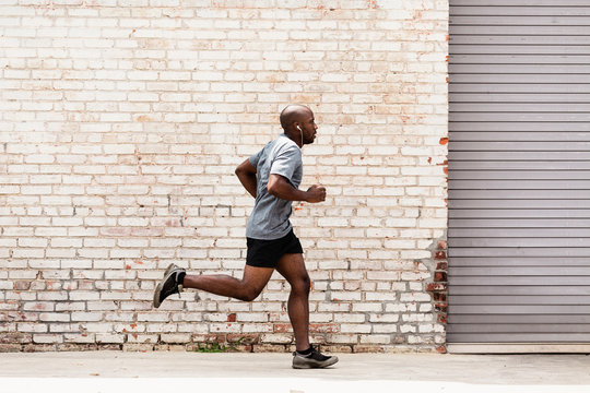 Black man running on city sidewalk