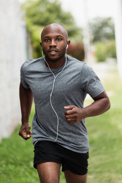Black man running in urban grass