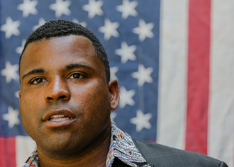 Close up of Black man in front of American flag