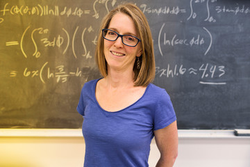 Caucasian teacher standing at chalkboard