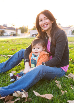 Hispanic mother sitting with son in park
