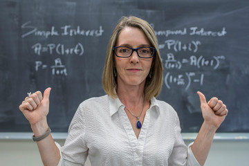 Caucasian teacher cheering at chalkboard