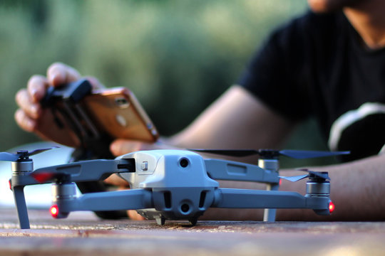 Stock photo of unrecognizable man setting up drone's camera parameters
