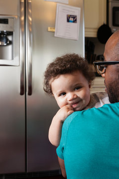 Father holding baby in kitchen