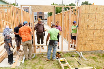 Volunteers holding wall at construction site