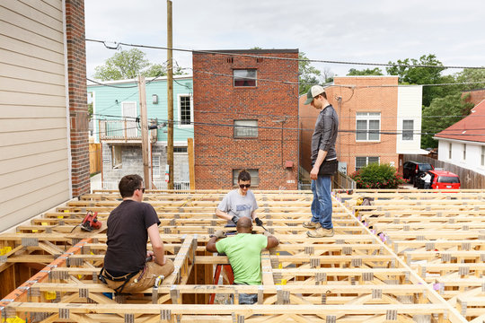 Volunteers On The Roof At Construction Site