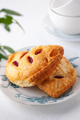 two puff buns with raspberries on a vintage plate on a white background close-up.