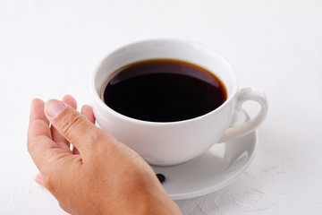 women's hands hold a white coffee mug on a white background.
