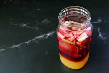 Vibrant Color of Homemade Red Wine Sangria before Mixing Isolated on Black Marble Table