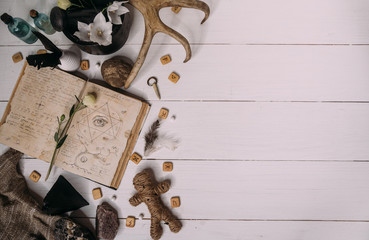 A voodoo doll made of rope lies with old book grimoire