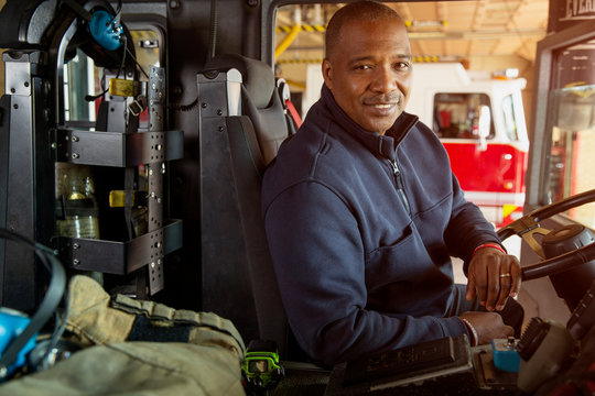 Portrait of fireman sitting in driver's seat of fire engine