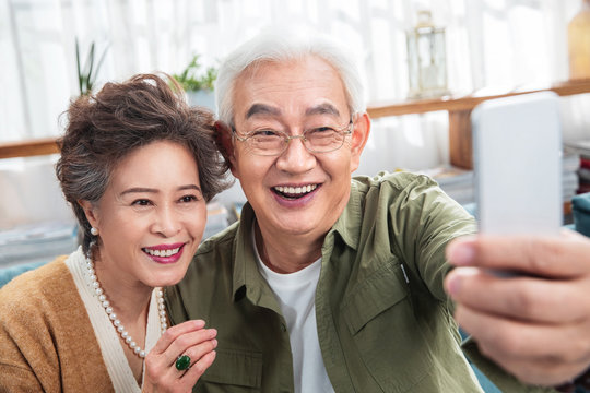 The old couple with cellphone picture of happiness