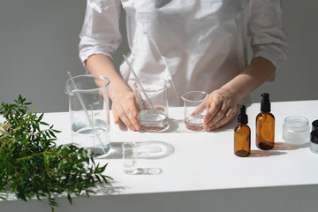 The scientist, dermatologist testing the organic natural cosmetic product in the laboratory. Vials, glass laboratory flasks. Beauty cosmetic research and development concept.