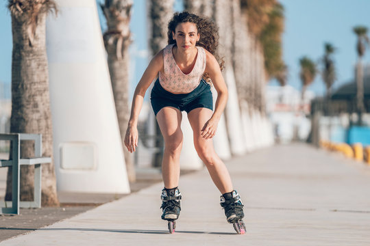Young woman inline skating on promenade at the coast