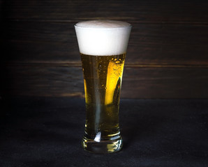 Glass of beer on dark wooden background