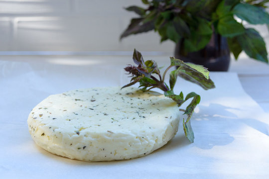 Fresh Salted Levantine Halloumi Cheese And A Sprig Of Basil On A White Background. Traditional Cypriot Cuisine.