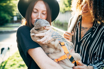 Close-up of couple playing with dog in park