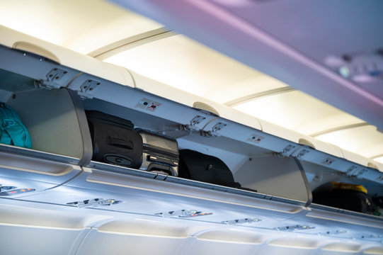 Carry-on luggage in overhead shelf in airplane cabin