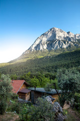Small wooden houses on the background of a high mountain.