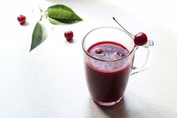 Glass mug with cherry juice on the kitchen table, close-up, side view,