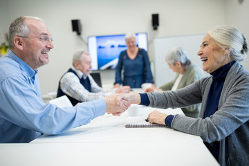 Senior citizens meeting at skill enhencement course, shaking hands