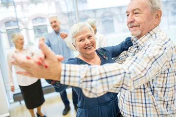 Group of active senior attending dance course in retirement home