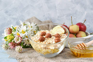 Oatmeal with hazelnuts and apples in a clear glass bowl