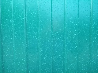 raindrops on a green painted metal surface