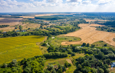 aerial photography of a winding river skirting a mown field