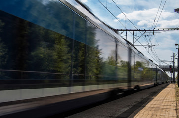 Naklejka premium Train in movement by rail with a blue sky