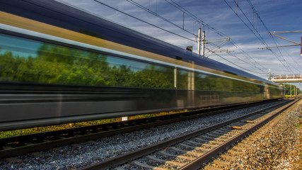 Obraz premium Train in movement by rail with a blue sky