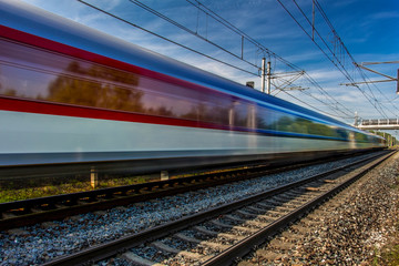 Fototapeta premium Train in movement by rail with a blue sky