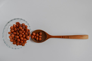 Hazelnuts  and spoon on a white background. 