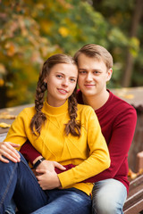 portrait of a happy young couple in colorful sweaters in an autumn Park