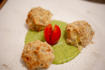 Polpette di carne, pinoli, e pan grattato con crema, pomodorino, olio e basilico 