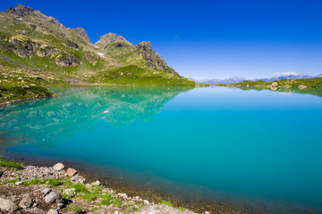 Alpine mountain lake at the daytime, sunlight and colorful landscape